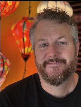 Rossco Paddison in front of red lanterns in Southeast Asia